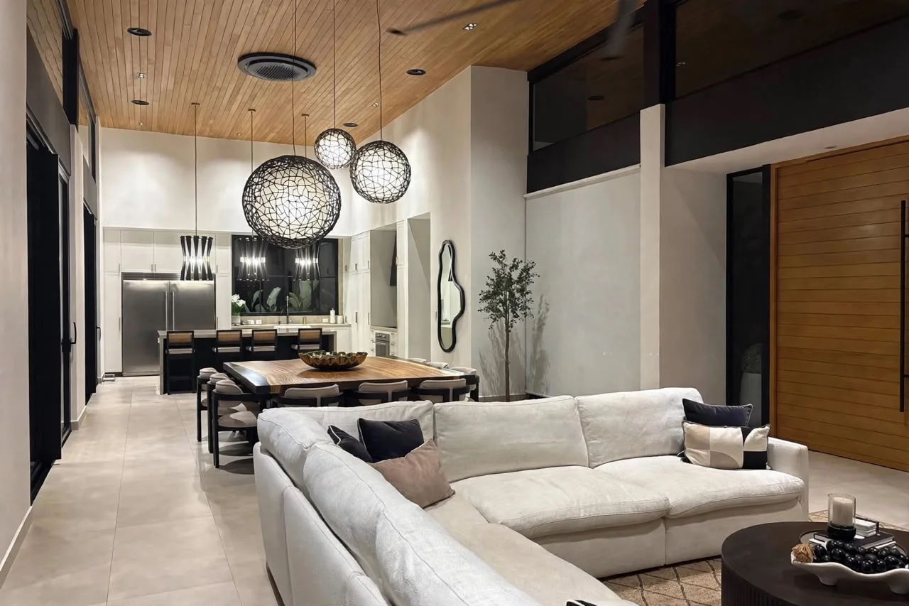 Casa 5 living room with a white sectional sofa, timber ceiling and pendant lights