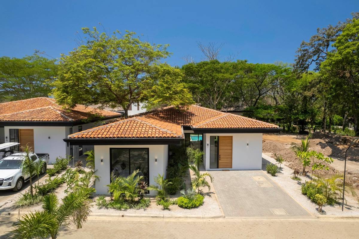A guest arriving at the open front door of a Hacienda Pinilla home